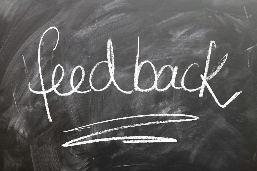 The word "feedback" is written in white chalk on a blackboard, with a white line drawn underneath.